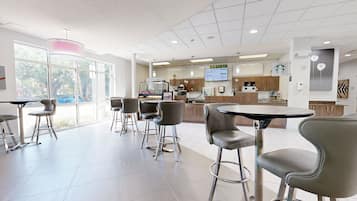 A modern cafe with barista stations, seating areas, and a visible Starbucks logo.