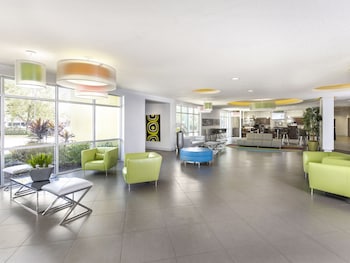 A modern lobby with a seating area, large windows, and a minimalist design. at Avanti International Resort