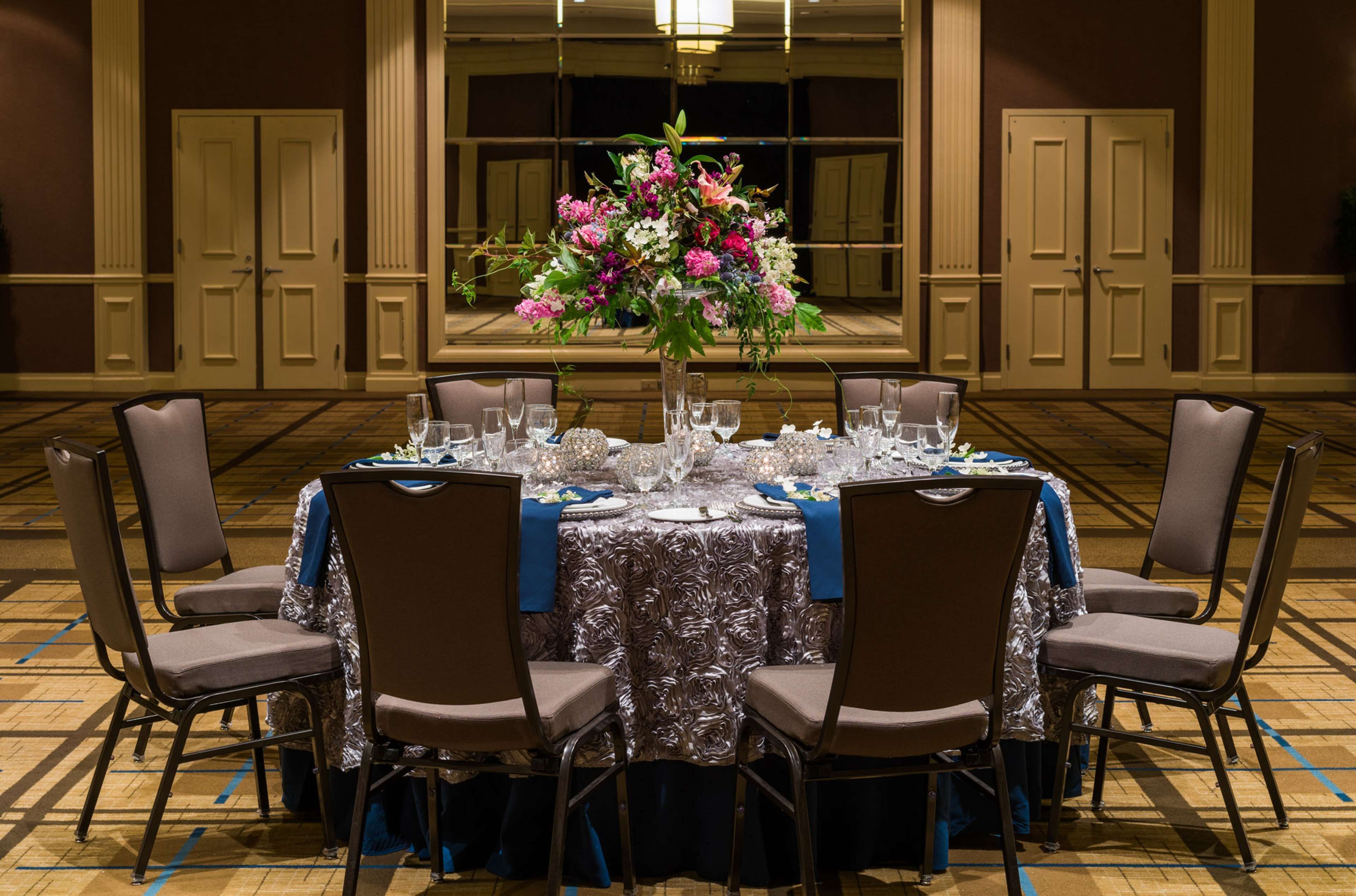 A conference room with a round table set for a meeting, surrounded by chairs.