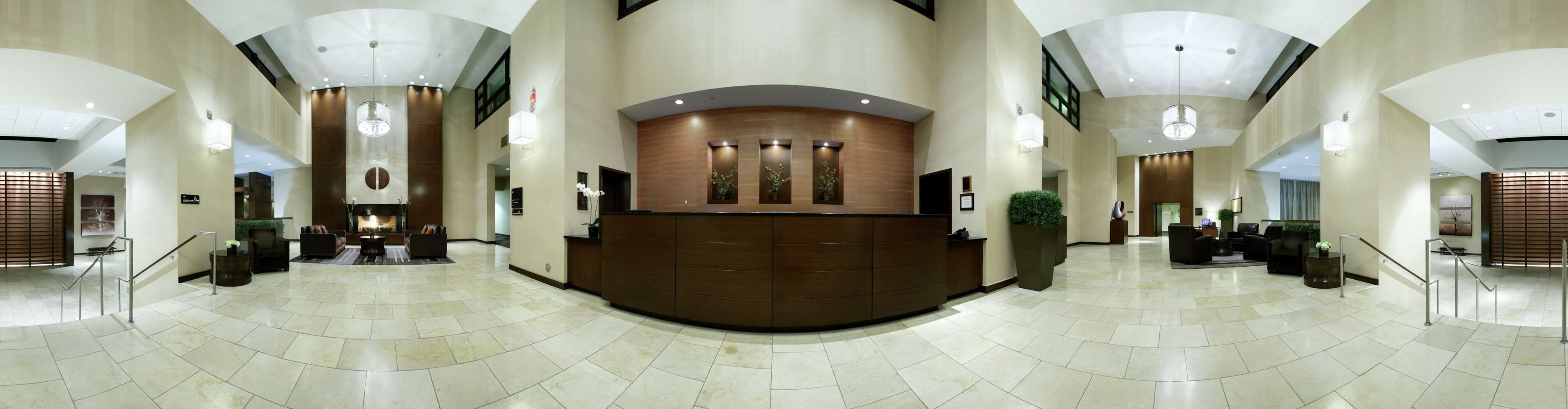 A spacious lobby with a reception desk, seating area, and a fireplace.