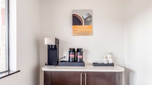 A coffee station with a coffee machine, two coffee dispensers, and a coffee cup display.