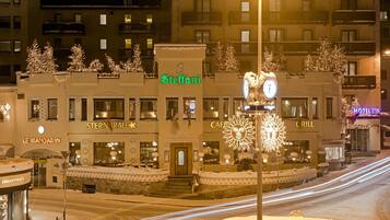 A hotel with a snow-covered entrance, decorated with lights and snowflakes.