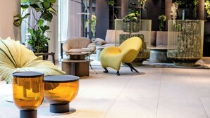 Un vestíbulo moderno con zonas de estar, una planta grande e iluminación decorativa.