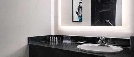 A modern bathroom with a black countertop, a white sink, and a large mirror.