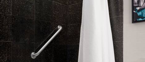 A modern bathroom with a bathtub, a shower, and a toilet.