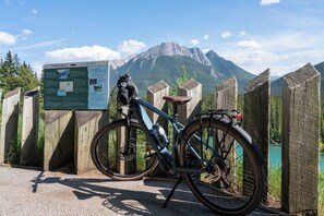 A bicycle parked next to a wooden fence with a signboard in the background.