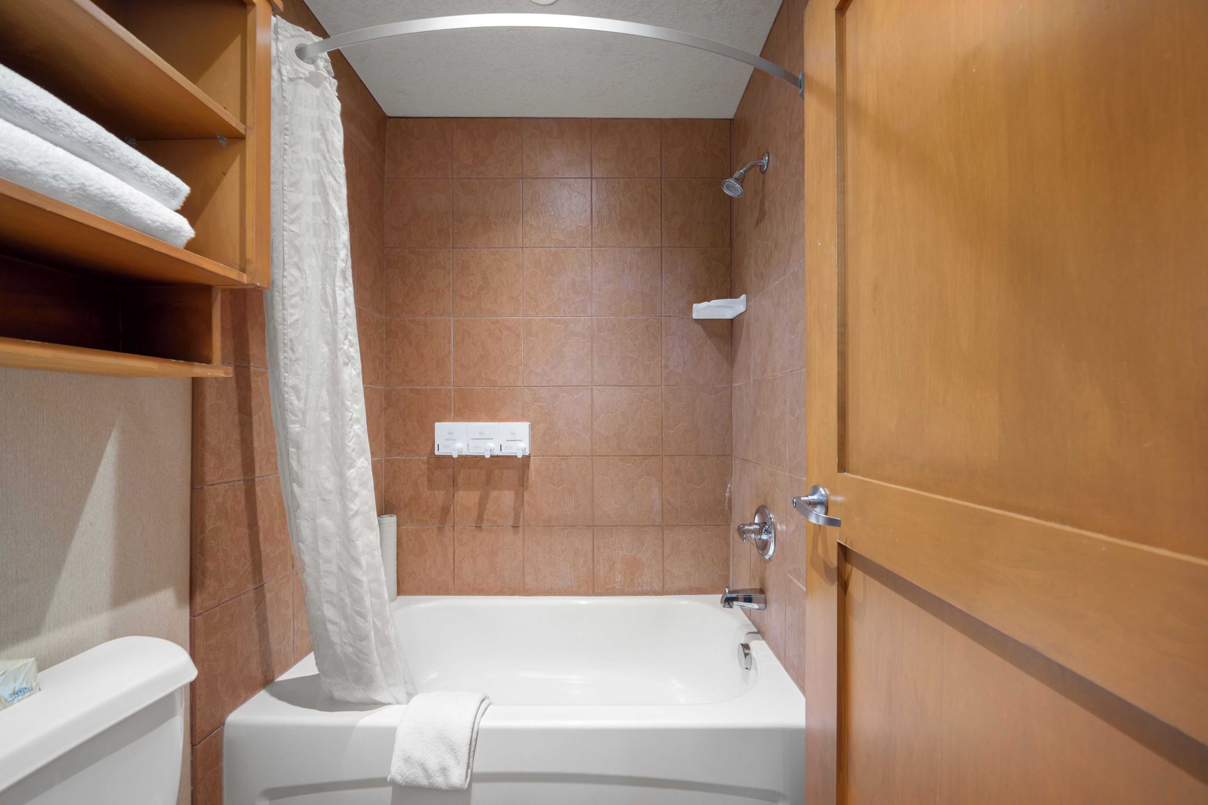 Un baño con bañera, inodoro y zona de ducha.