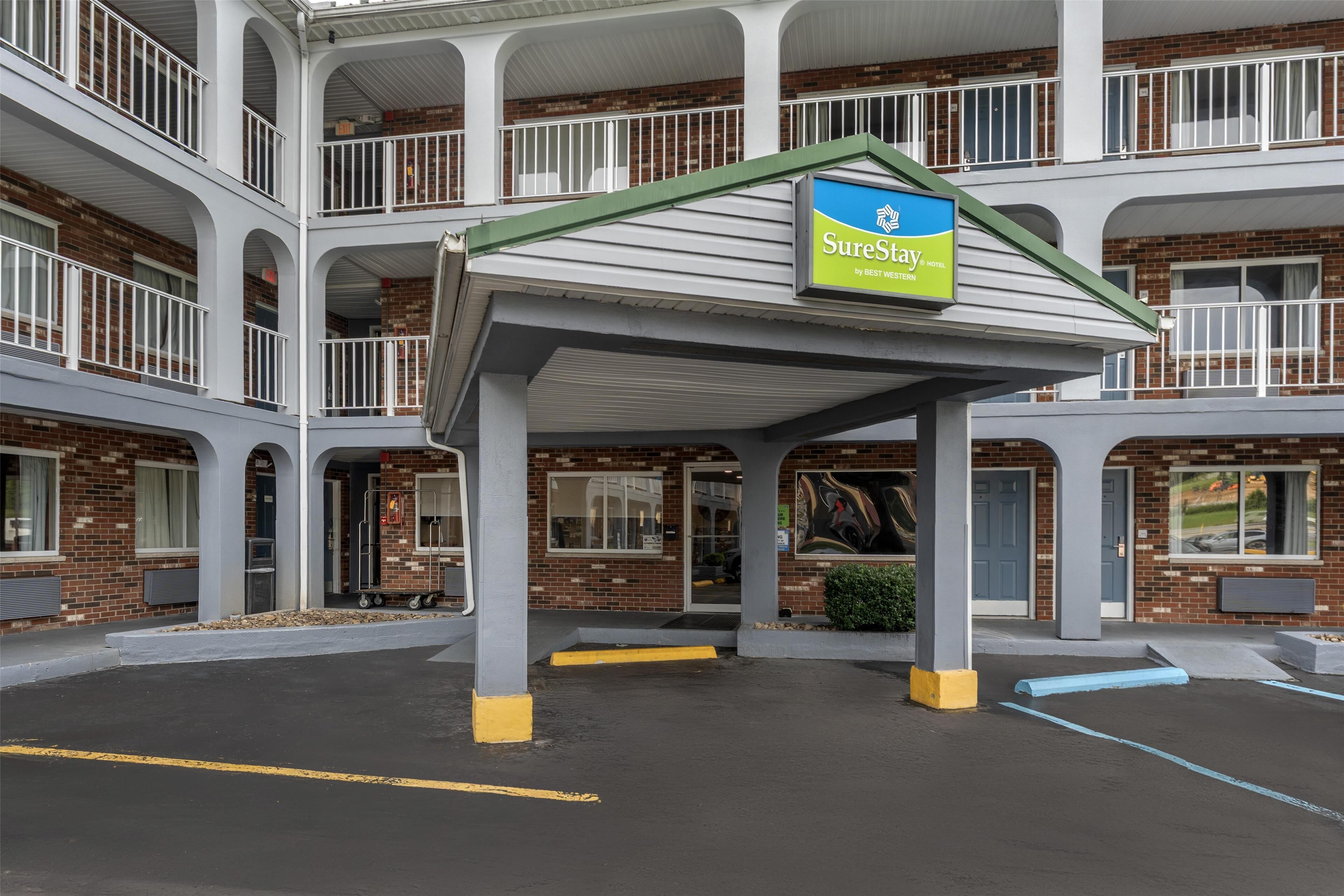 A multi-story hotel with a covered entrance and a sign for SureStay by Best Western.