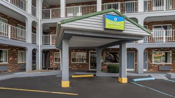 A multi-story hotel with a covered entrance and a sign for SureStay by Best Western.