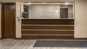 A reception desk at SureStay Hotel by Best Western with a brown door and a digital keycard reader.
