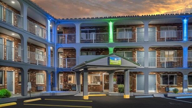 A multi-story hotel with a central atrium, a SureStay sign, and a parking lot.