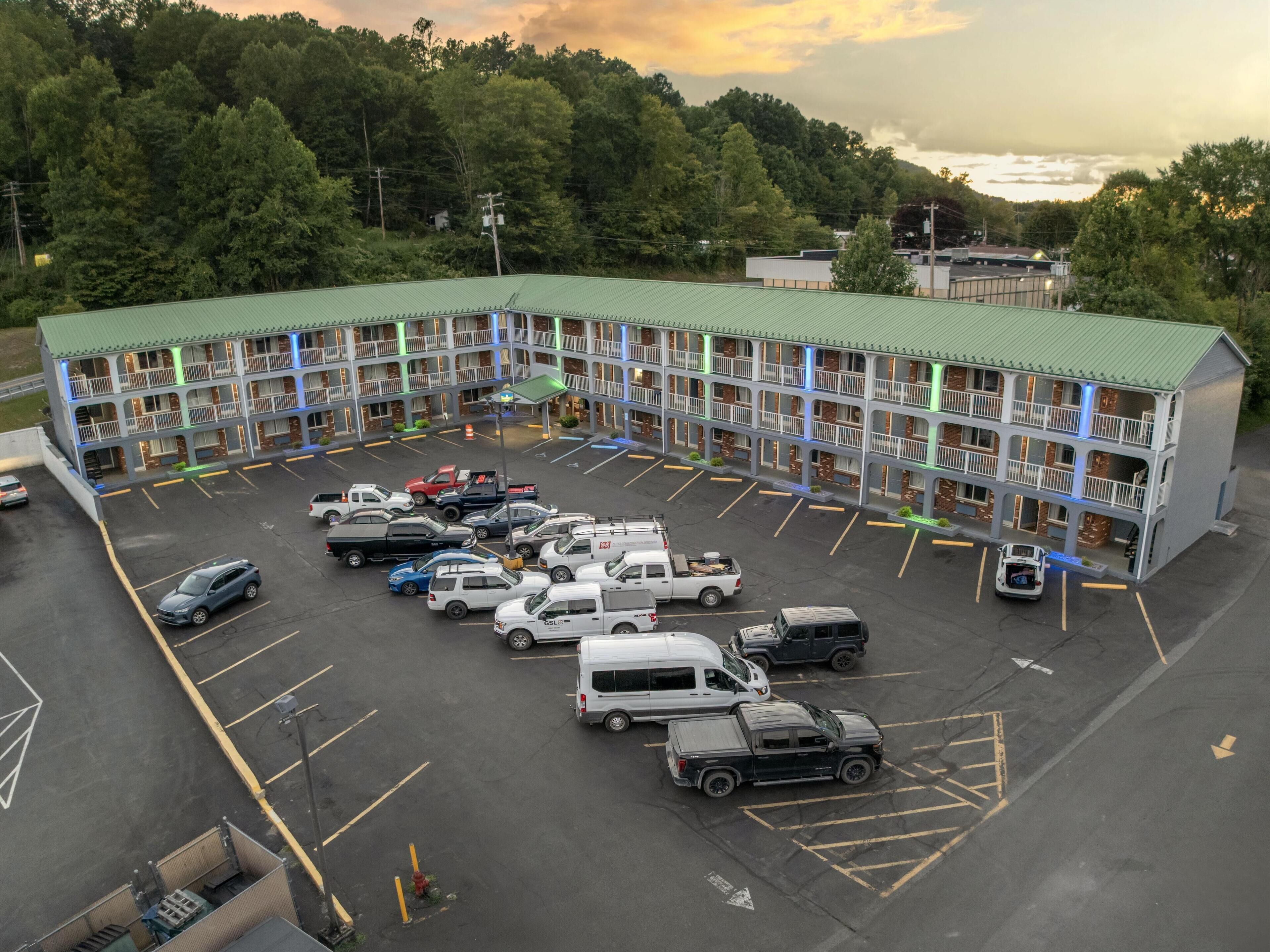 A multi-story motel with a green roof parking lot.