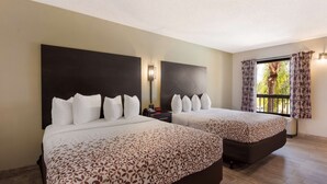 A hotel room with two beds, a large window with curtains, a nightstand, and a wall-mounted lamp. - SureStay Hotel by Best Western St. Pete Clearwater Airport (Clearwater)