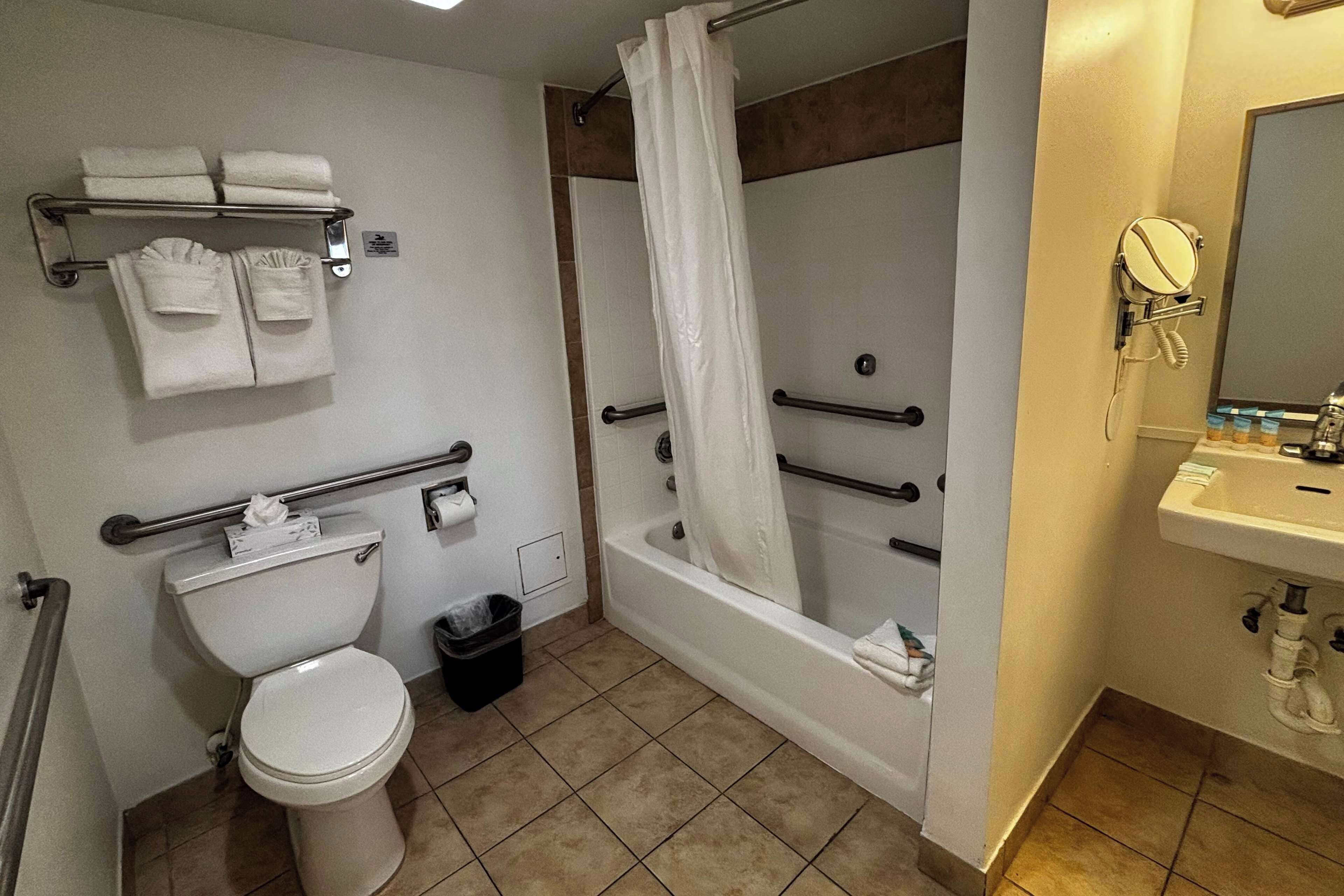 A bathroom with a toilet, sink, bathtub, and shower.