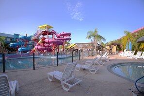 A water park with multiple slides and a pool area with lounge chairs. - Ramada by Wyndham Hotel & Water Park (Kissimmee)