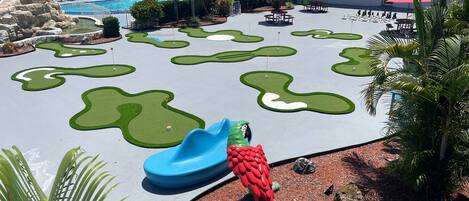 A pool area with multiple water features and a slide.