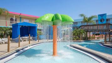 A pool area with a central water feature, a covered seating area, and a building with a pink roof.