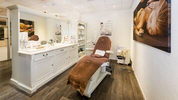Experience relaxation in this serene spa room, featuring a spacious vanity and a comfortable massage chair.