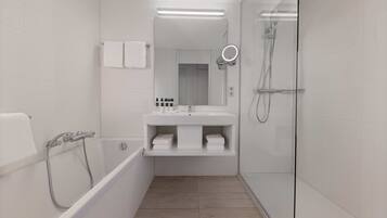 Un baño moderno con bañera, ducha con mampara de vidrio y tocador con espejo.