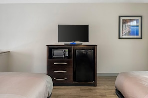 A hotel room with a bed, a TV on a cabinet, a microwave, and a refrigerator. - Quality Inn & Suites Live Oak I-10 Exit 283 (Live Oak)