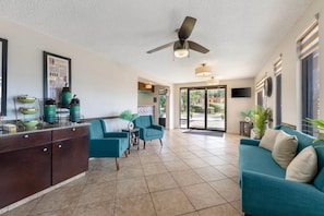A spacious living area with a coffee station, teal sofas, and a ceiling fan. - Quality Inn & Suites Live Oak I-10 Exit 283 (Live Oak)