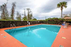 Una piscina al aire libre, sombrillas, tumbonas
