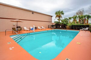 Una piscina al aire libre, sombrillas, tumbonas