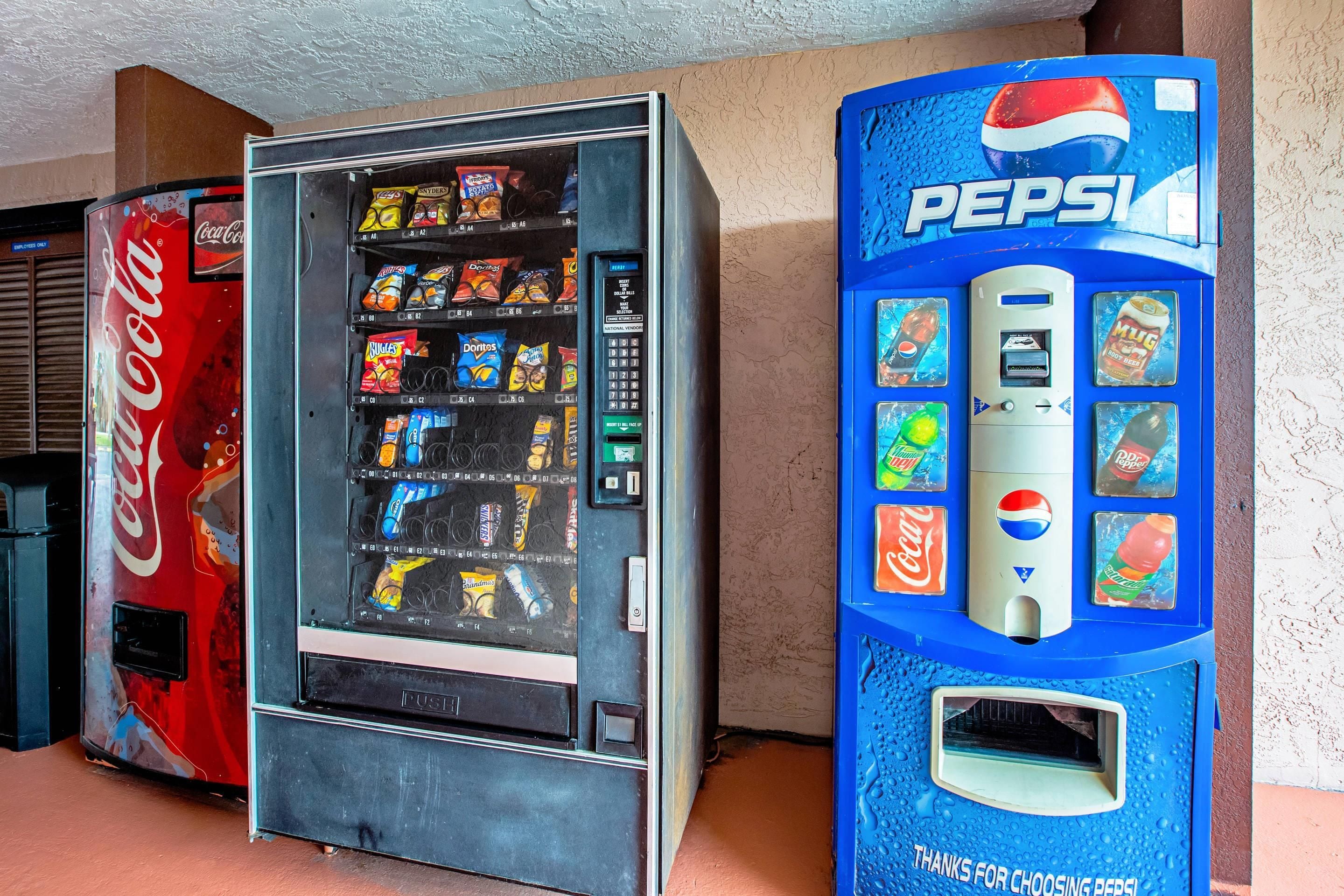 Máquina de vendas com logotipo da Coca-Cola e outra máquina de Pepsi com esquema de cores azul.