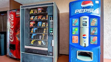 Máquina de vendas com logotipo da Coca-Cola e outra máquina de Pepsi com esquema de cores azul.