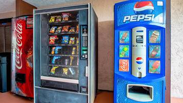 Una máquina expendedora con el logotipo de Coca-Cola y otra máquina de Pepsi al lado.