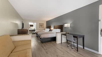Una habitación de hotel con cama, escritorio, silla y sofá.