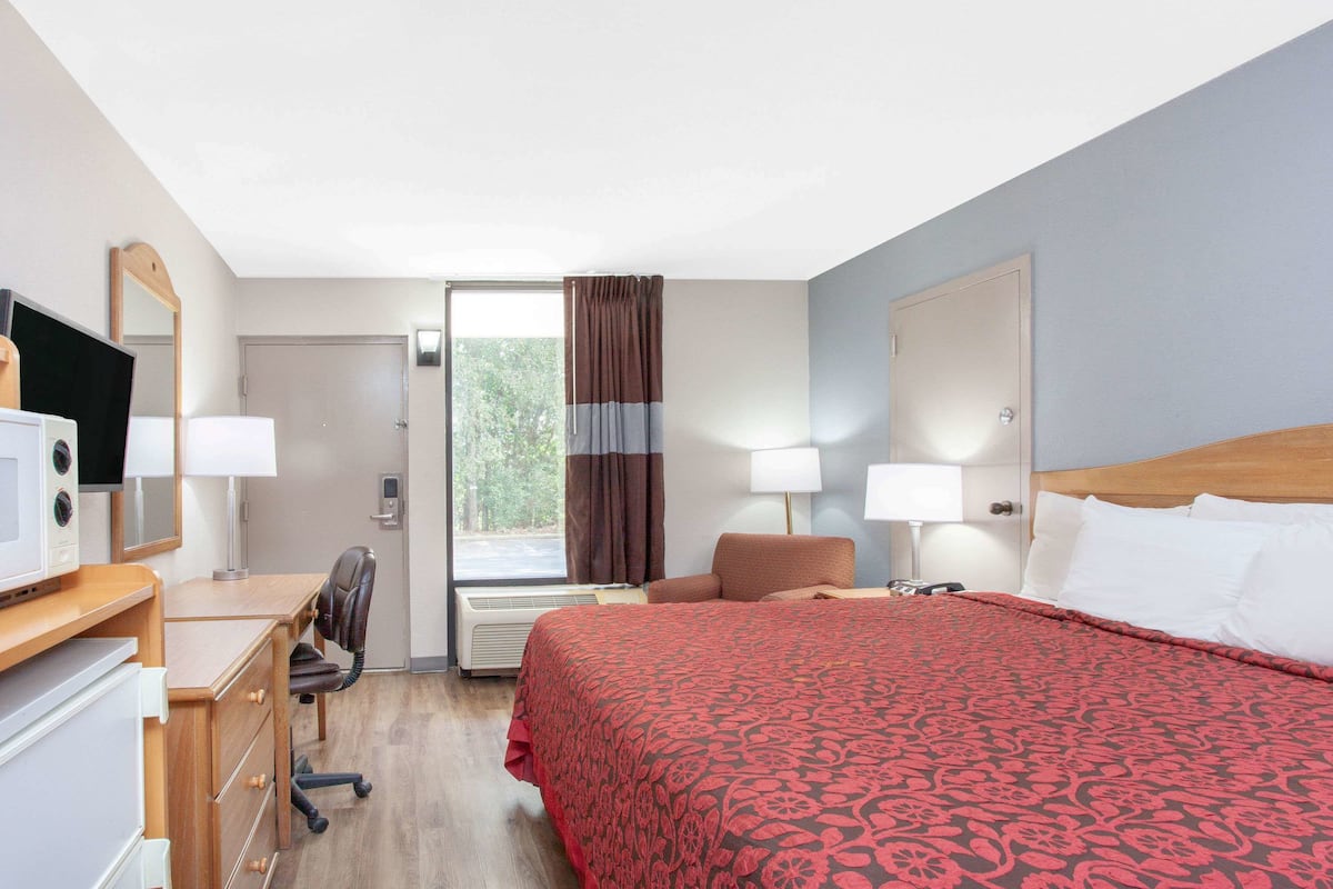 Escritorio, cortinas blackout y tabla de planchar con plancha