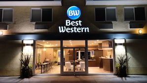 En hotellentrén med en skylt som visar ”BW Best Western”, glasdörrar och ett sittområde som syns inifrån.