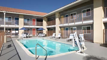 Een buitenzwembad, parasols voor strand/zwembad