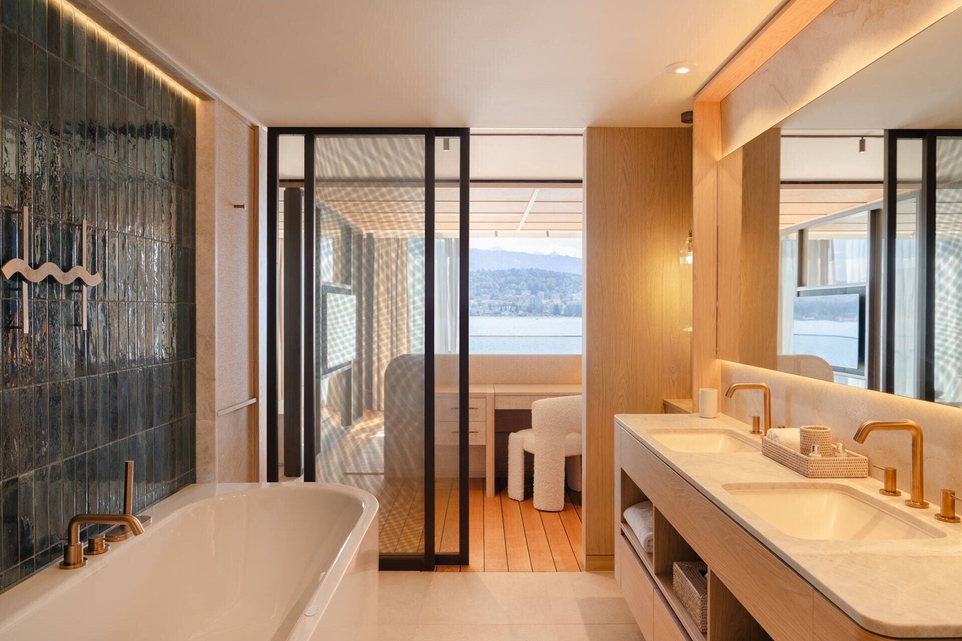 Un baño moderno con bañera, dos lavamanos y un espejo grande.