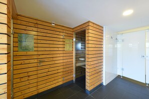 A wooden interior with a glass shower enclosure and a tiled floor.