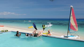 Una piscina al aire libre, sillones reclinables de piscina
