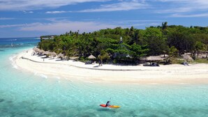 A beach with clear turquoise waters, a sandy shore, and a small island with trees and a building. - Nakelo Treasure Island Resort & Spa (Treasure Island)