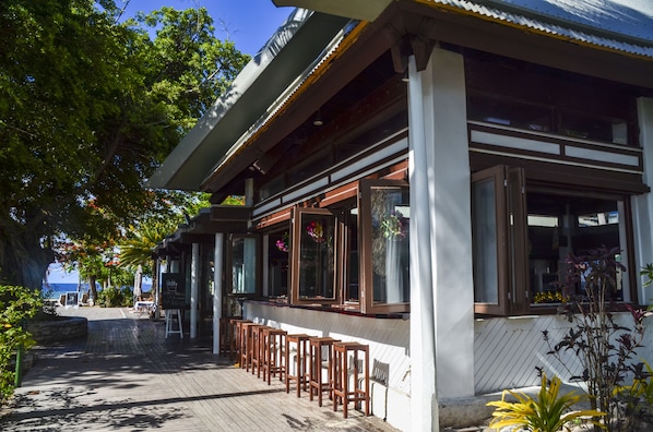 A coastal building with a wooden deck, large windows, and outdoor seating. - Nakelo Treasure Island Resort & Spa (Treasure Island)
