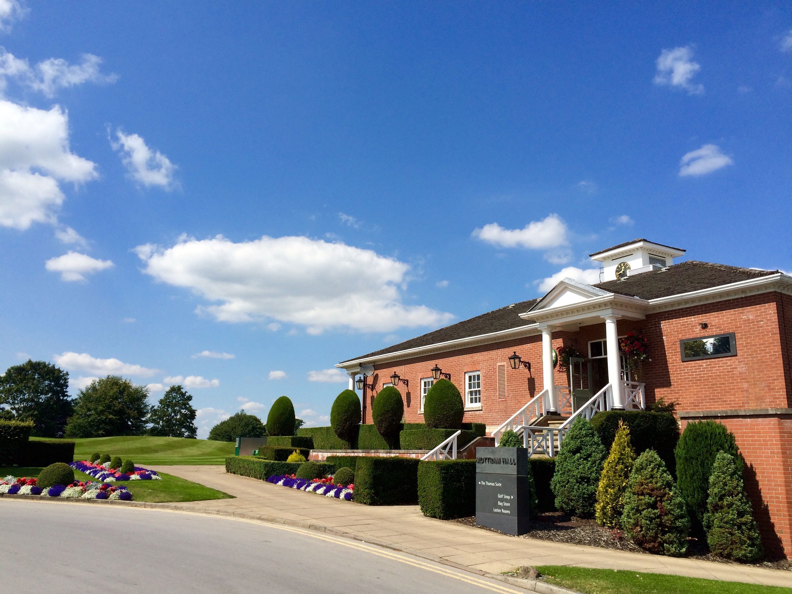 A brick building with a central entrance, steps, and a clock tower.
