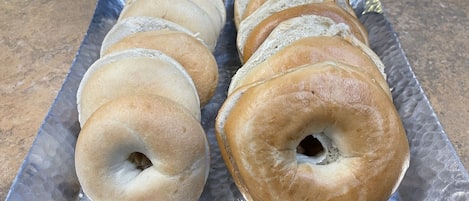 A tray of bagels on a metallic surface.