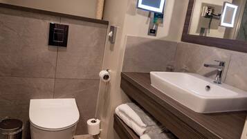 Un baño moderno con inodoro, bidé y lavamanos.
