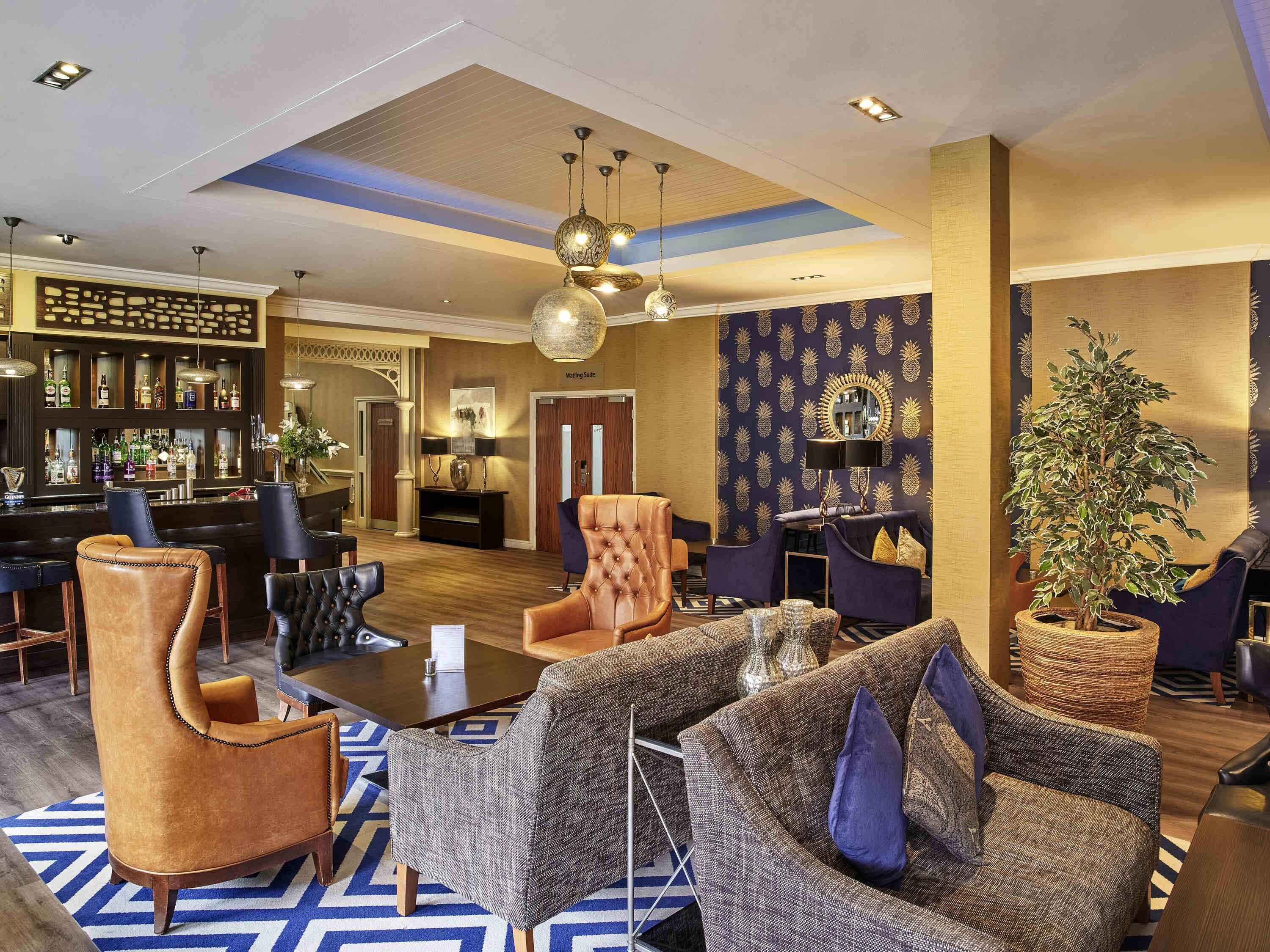 A hotel lobby with a bar, seating area, and a 'Walling Suite' sign.