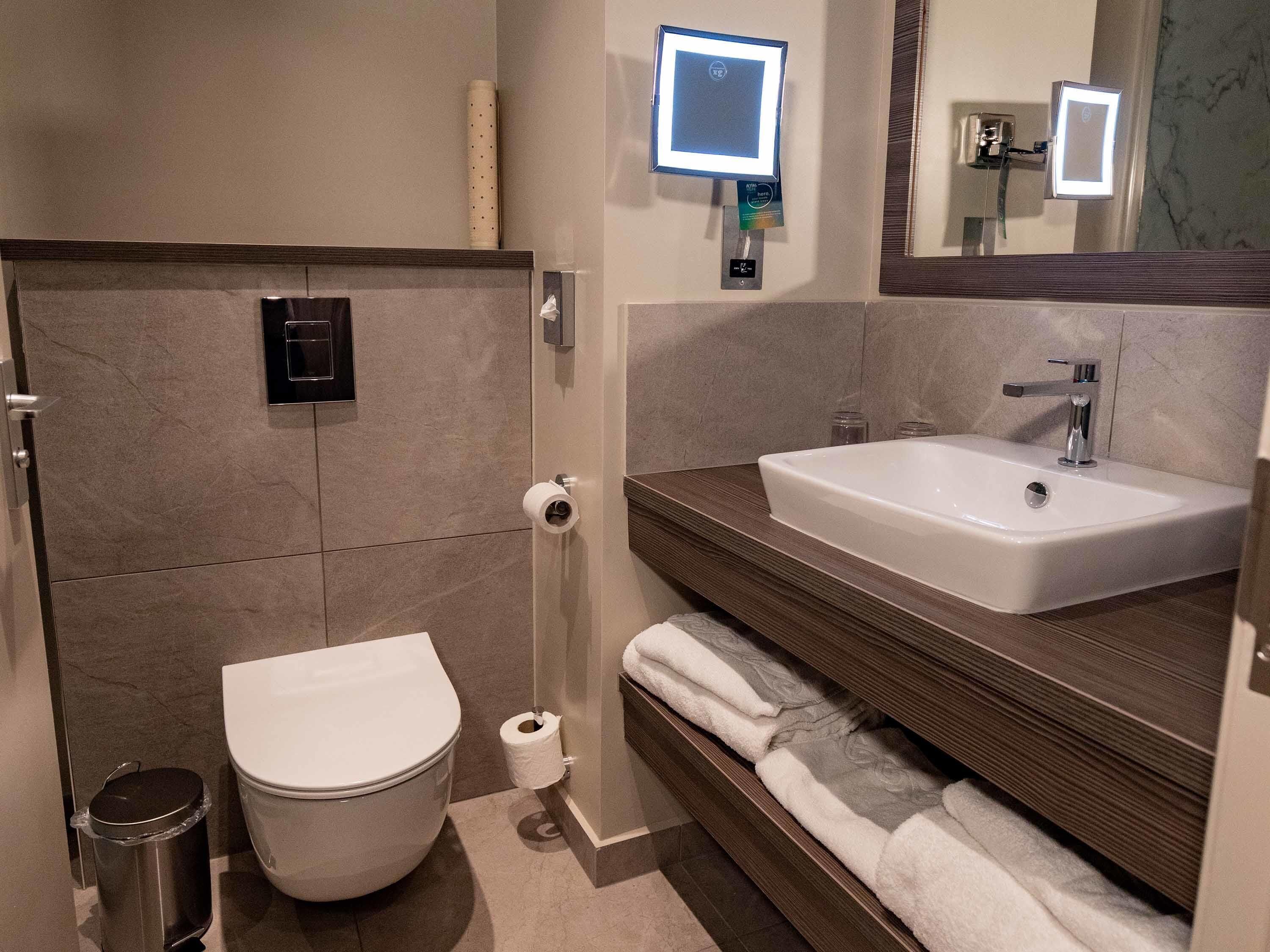 Un baño moderno con inodoro, lavabo, bidé y toallero.