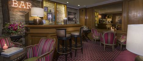 A bar area with striped chairs, a bar counter, and a patterned floor.