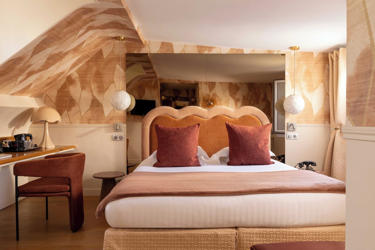 A bedroom with a bed, a desk, and a chair.