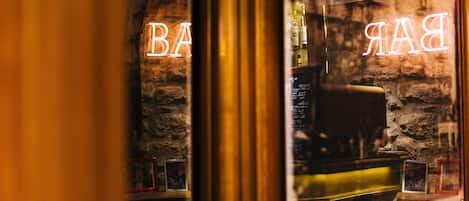 Un bar con letreros de neón que dicen "BAR" y un fondo de pared de piedra.