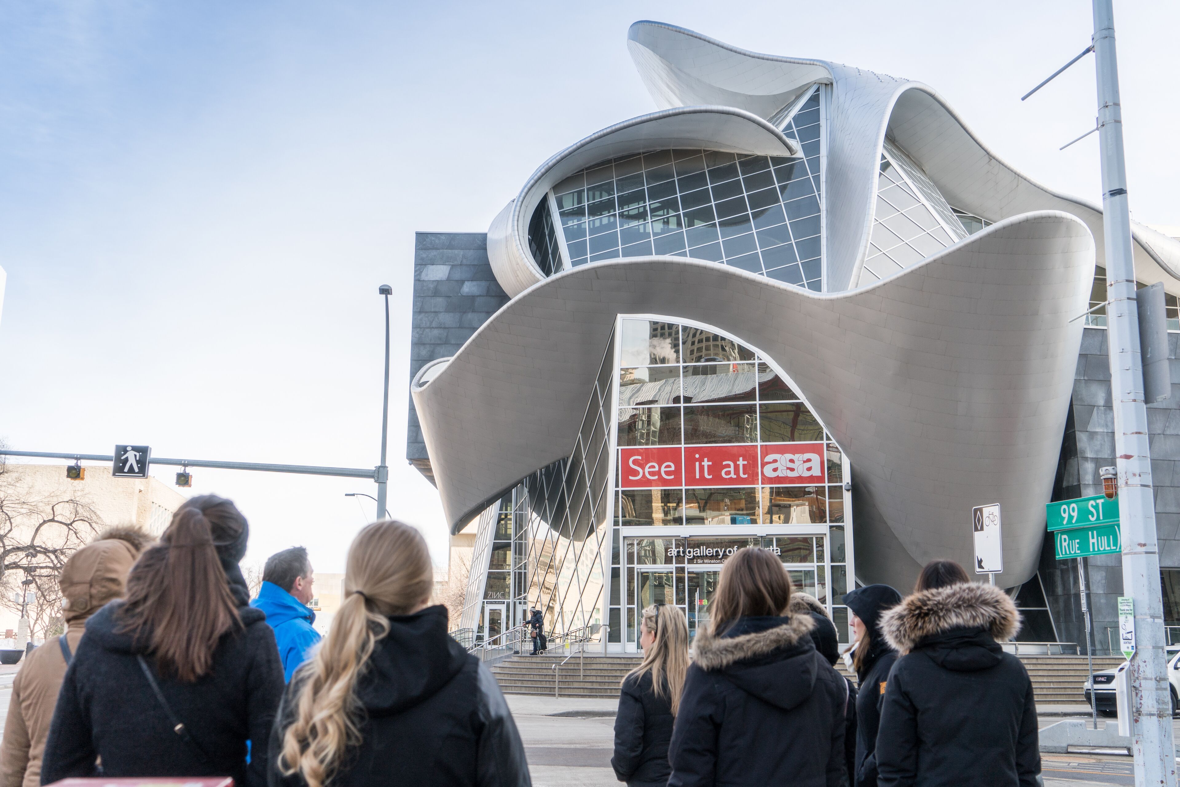A modern building with a unique curved exterior and a glass facade.