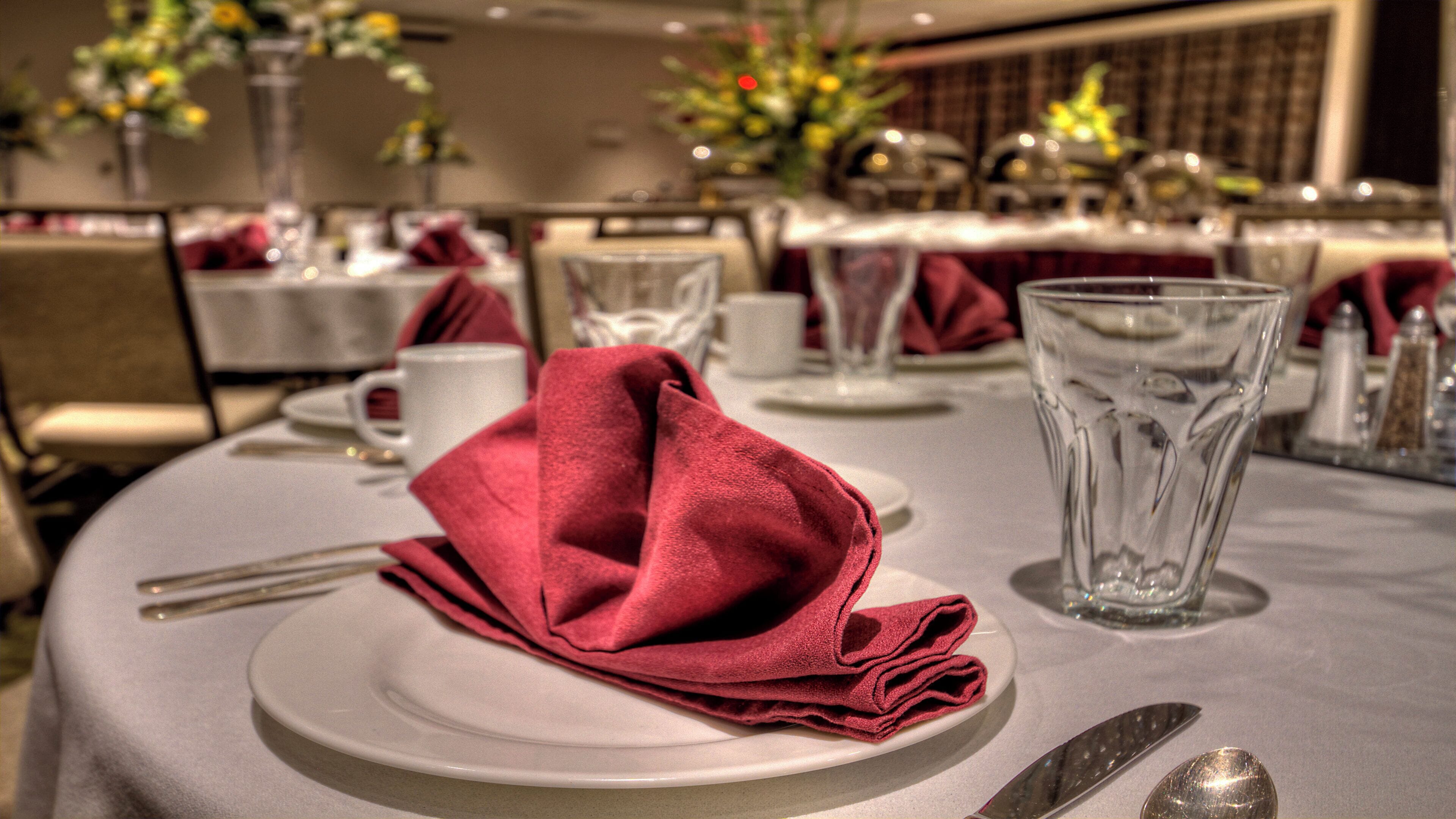 A table set for dining with a folded napkin, a glass, and cutlery.