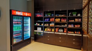 Ein Getränkeautomat mit Coca-Cola-Logo und ein Snackautomat, gefüllt mit verschiedenen Artikeln.